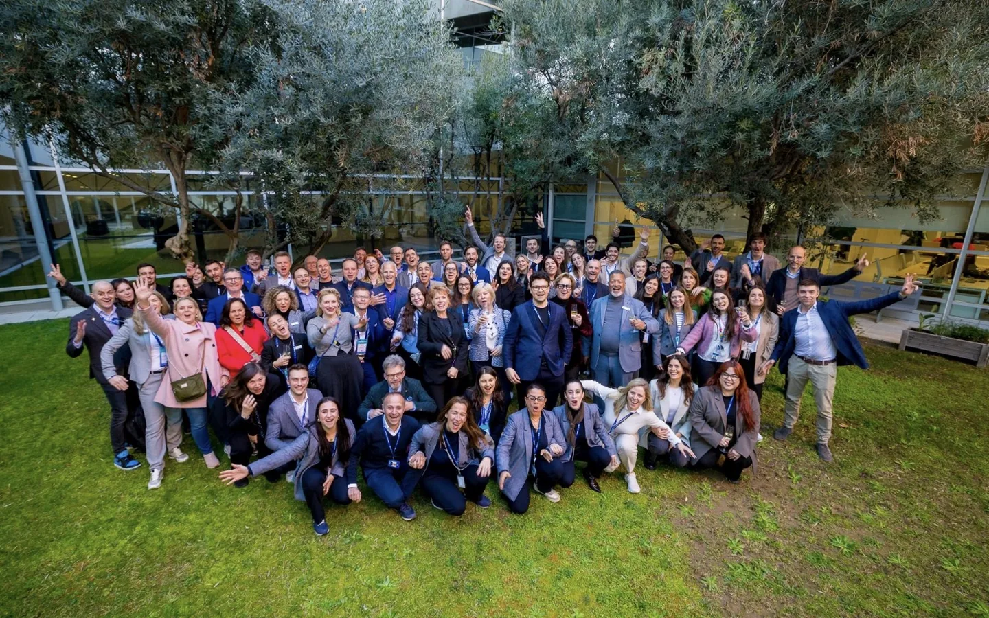 A large group of delegates photographed together outdoors on a lawn