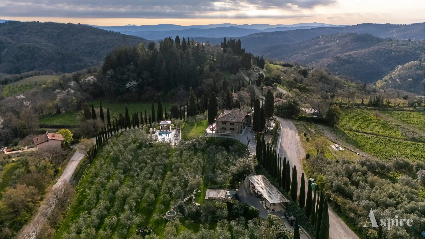 Aerial panorama of a villa estate in the Tuscan hills at dusk