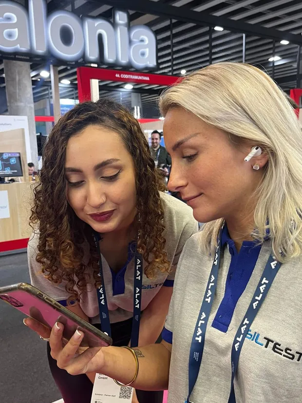 Two of the team reviewing something on a phone at a conference