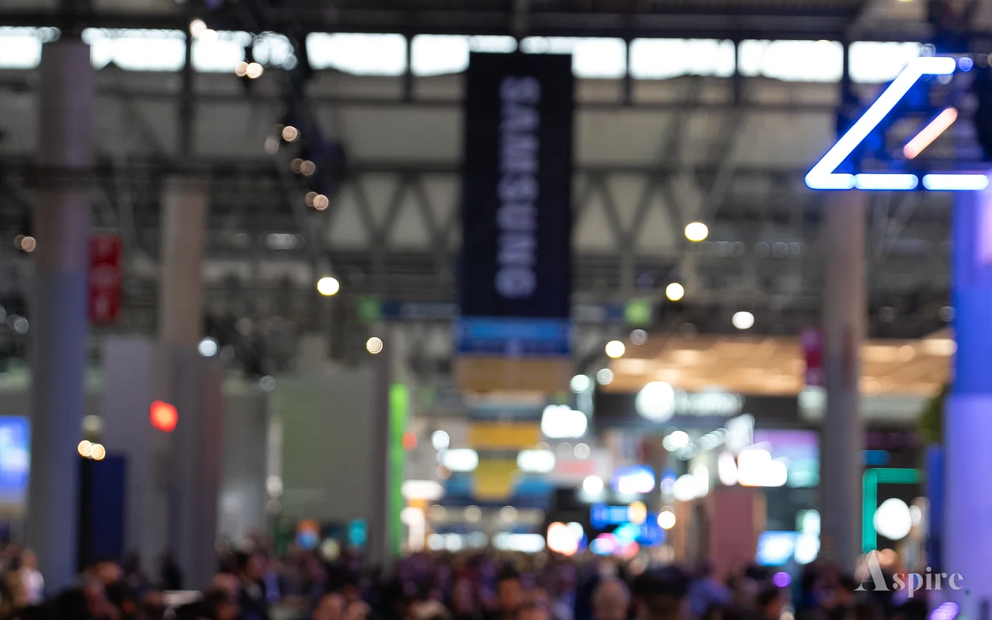 Crowded exhibition floor at a trade show, seen from above