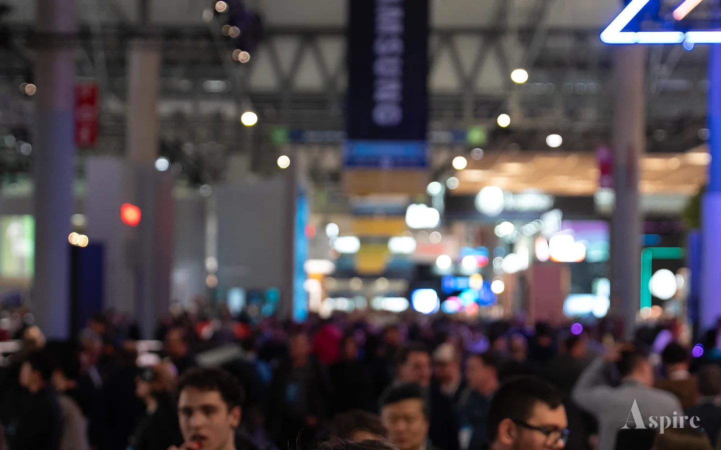 Crowded exhibition floor at Integrated Systems Europe under gantry signage